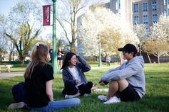 Students sit outside of the School of Education.